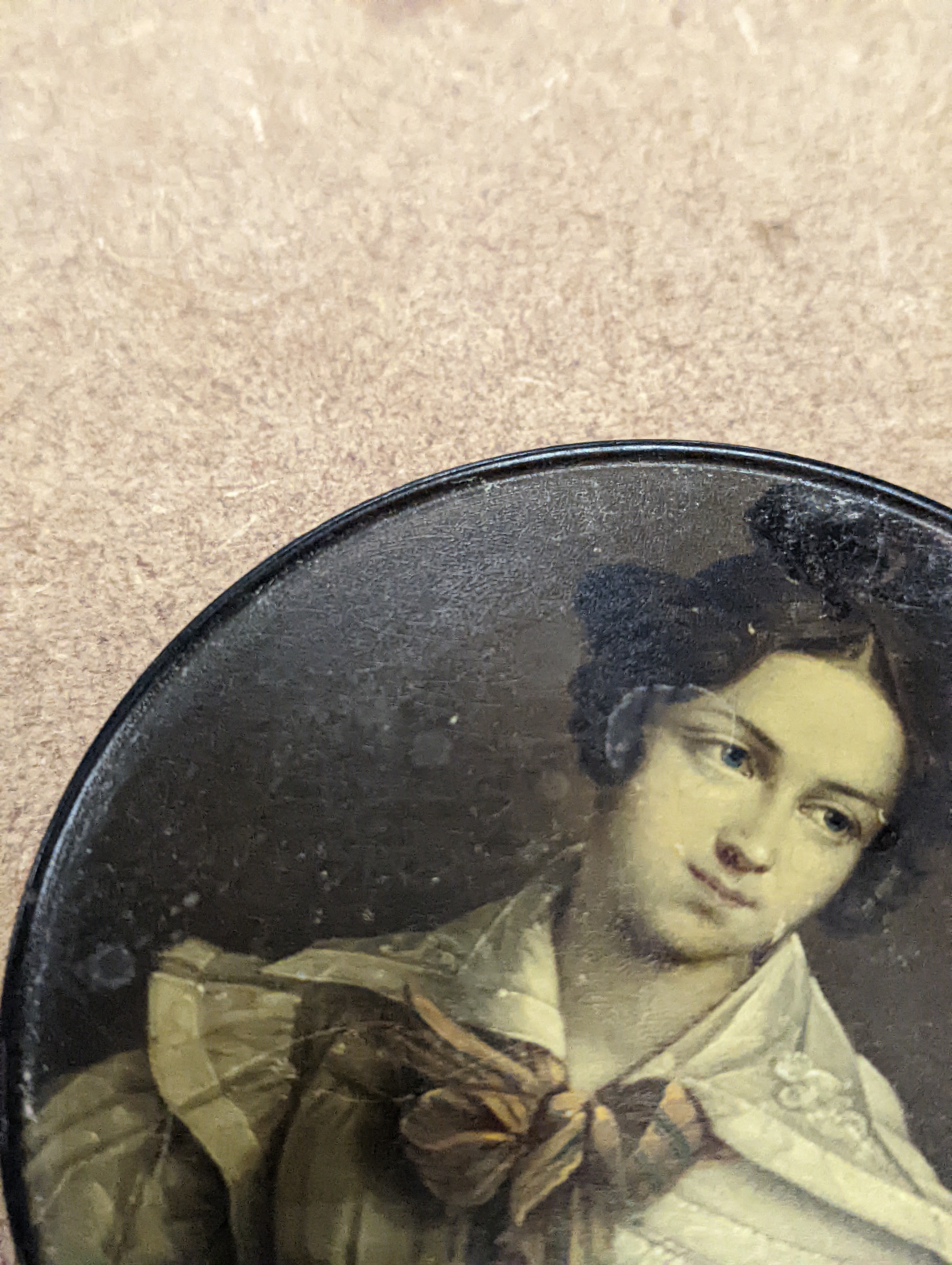 A 19th century Stobwasser papier mache ‘Henriette Sonntag’ portrait snuff box, c.1830, 9.7cm diameter and a 19th-century papier mache snuff box painted with a portrait of a German hussar, 9.4cm (2)